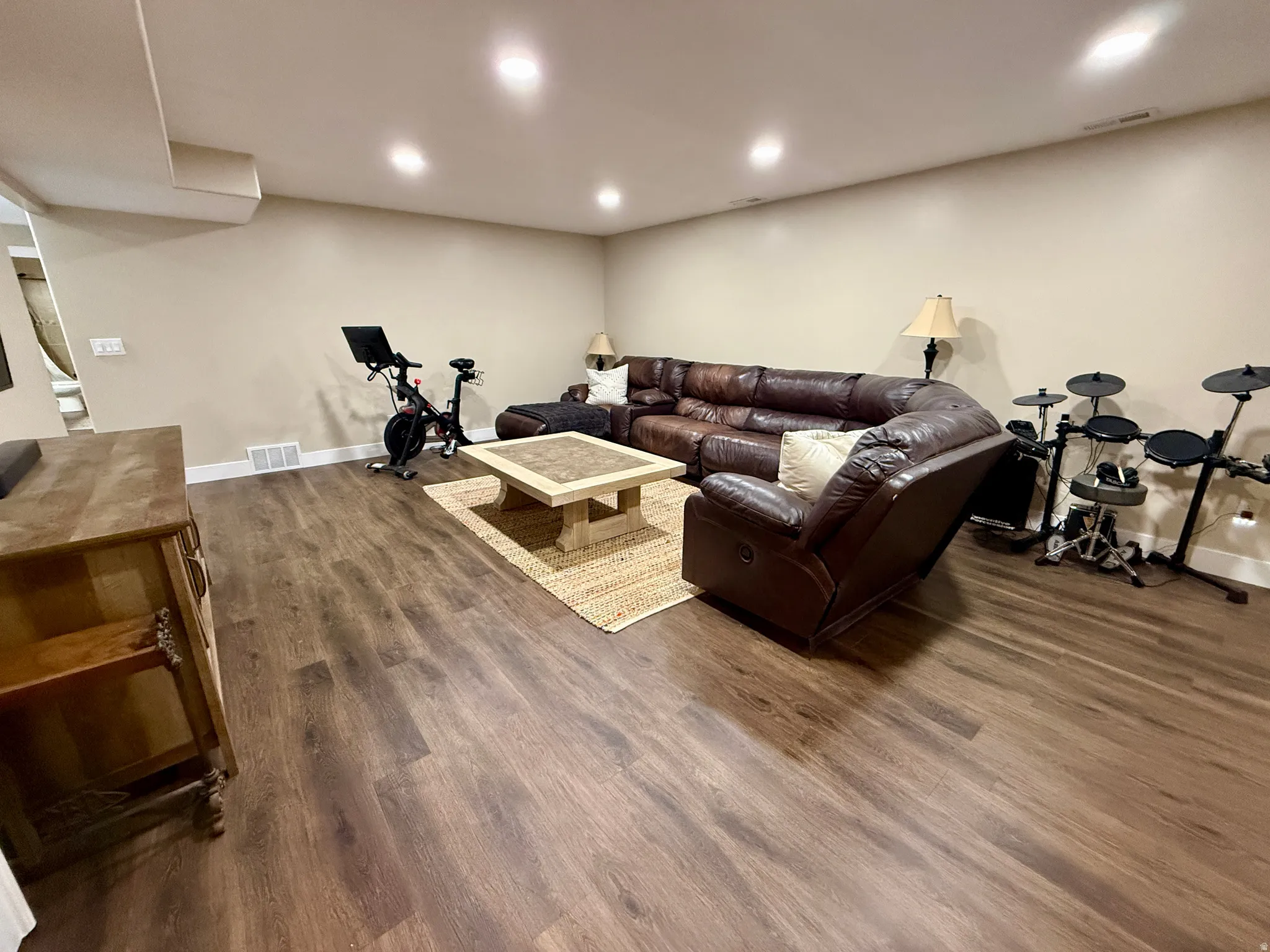 Spacious room featuring wood-finish flooring, recessed lighting, and neutral wall tones