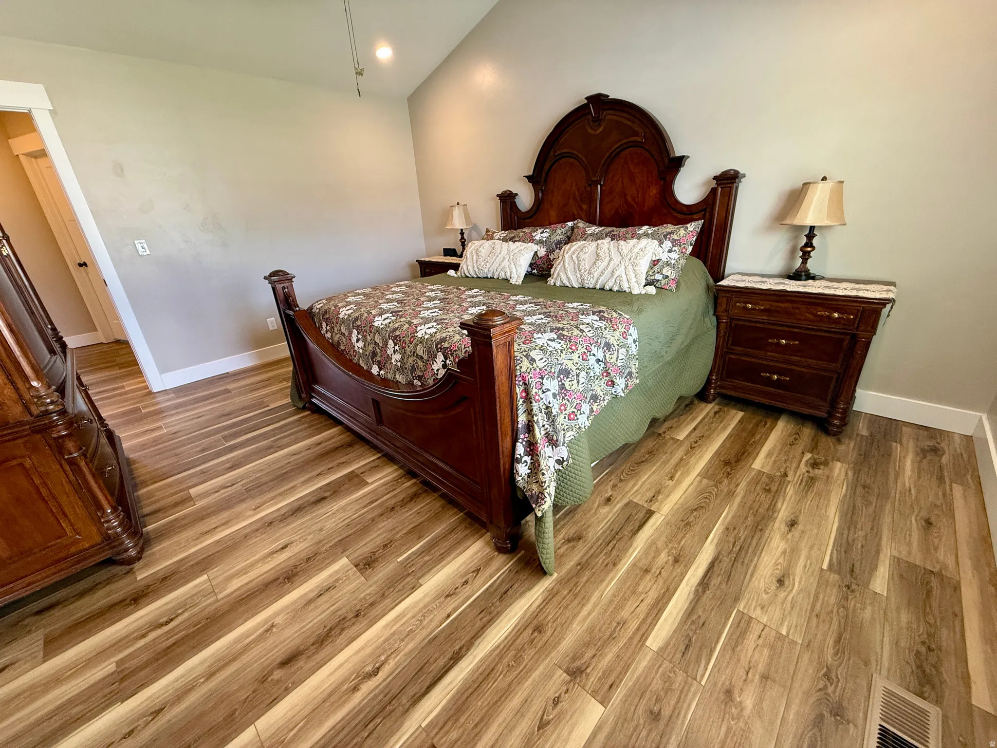Spacious room featuring wood-finish flooring, light-colored walls, and a recessed ceiling light