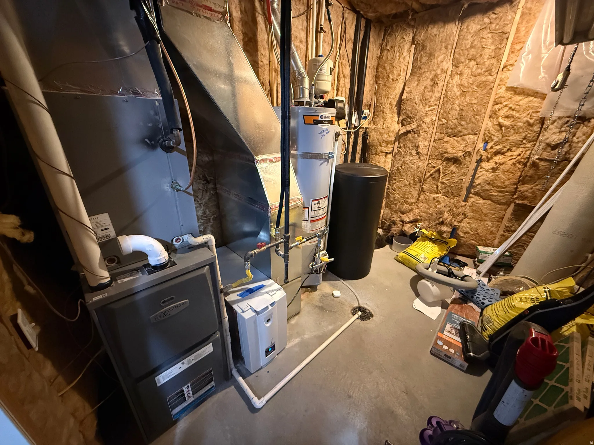 Utility area featuring a water heater, furnace, and exposed insulation