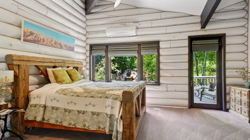 Interior space featuring white-washed log walls and dark wood ceiling beams