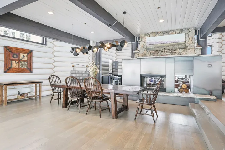Expansive dining area featuring wood-finish flooring and exposed log walls