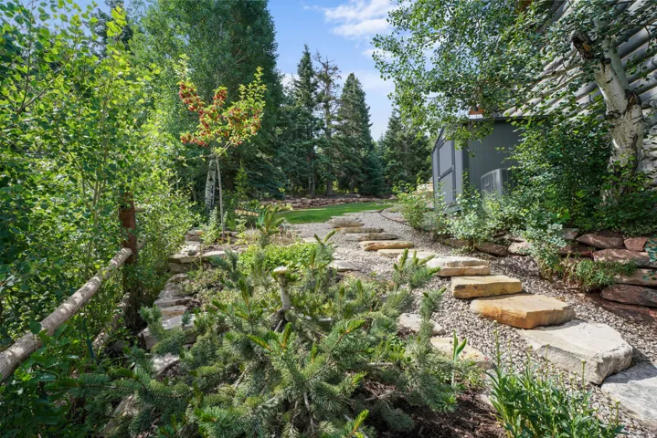 Stone paver pathway with gravel infill, leading through varied landscaping
