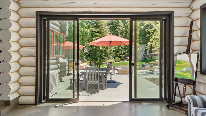 Sliding glass doors opening to an outdoor patio with stone paving