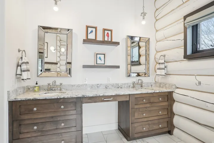 Dual vanity with integrated sinks, light-toned countertop, and dark wood-finish cabinetry