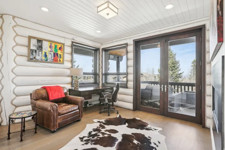 Room featuring log walls with a white finish, wood-finish flooring, and a white plank ceiling