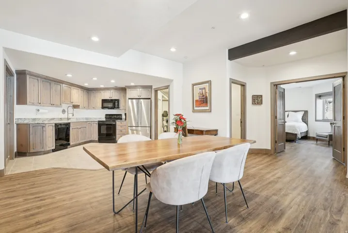 Open concept living space featuring wood-finish flooring, recessed lighting, and a dark wood beam accent