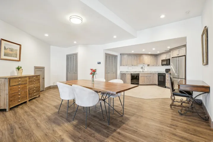 Open-concept kitchen and dining area featuring wood-finish flooring, recessed lighting, and a neutral color palette