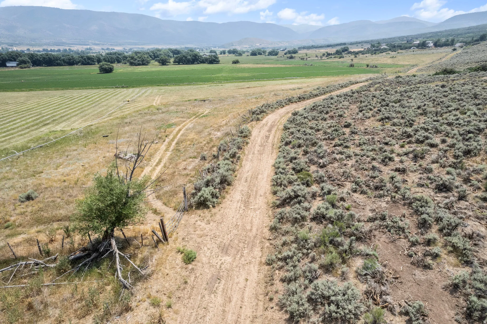 Expansive rural landscape featuring a winding dirt road and diverse terrain