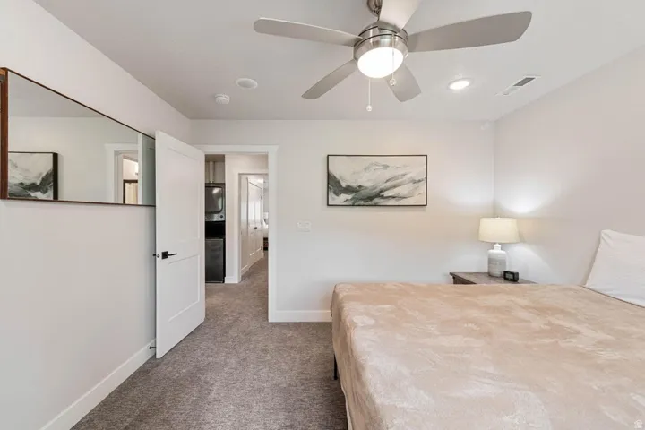 Room featuring neutral wall tones, gray carpeting, a ceiling fan with integrated lighting, recessed lighting, and a white interior door with matte black hardware