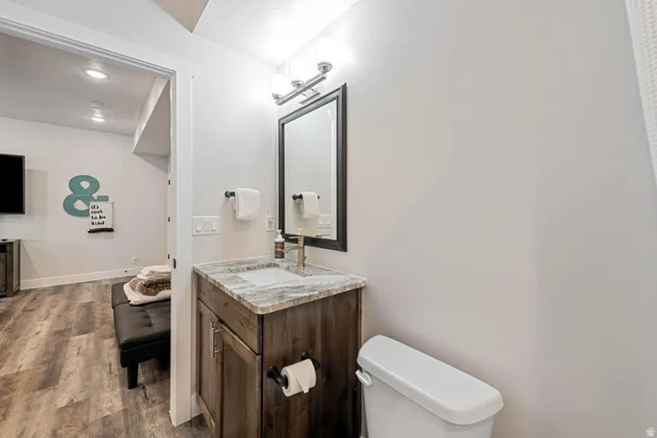 Bathroom vanity with a dark wood-finish cabinet, a light-toned stone-finish countertop, and a rectangular undermount sink with a brushed nickel faucet