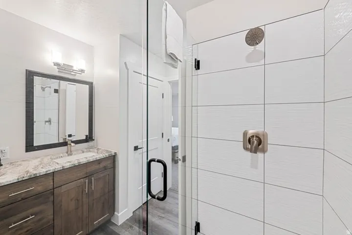 Contemporary bathroom featuring a spacious glass-enclosed shower with white tiled walls and a rain showerhead