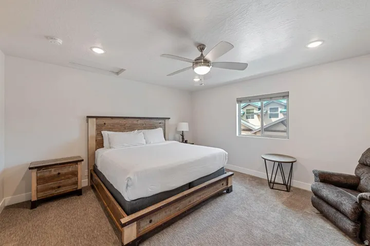 Carpeted bedroom featuring recessed lighting, a ceiling fan with light fixture, and a window with blinds