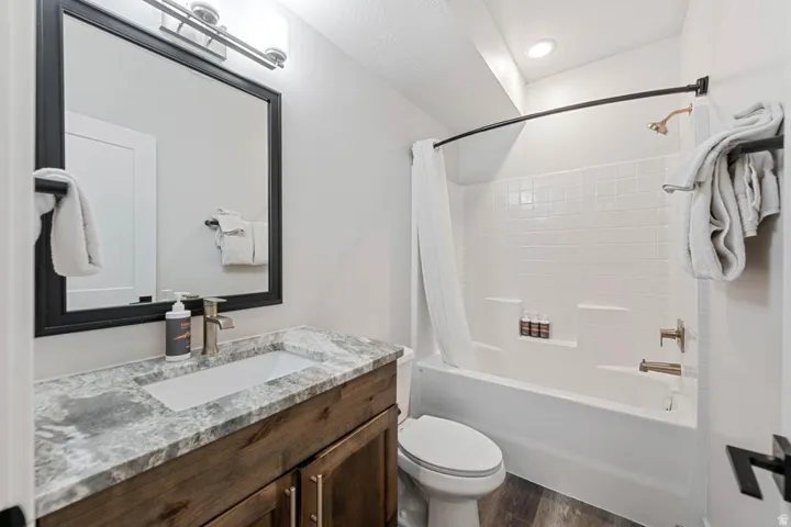 Contemporary bathroom featuring a wood-finish vanity with a stone-look countertop and an undermount sink