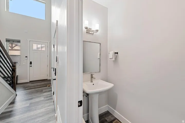 Pedestal sink with polished chrome faucet and wall-mounted vanity lighting