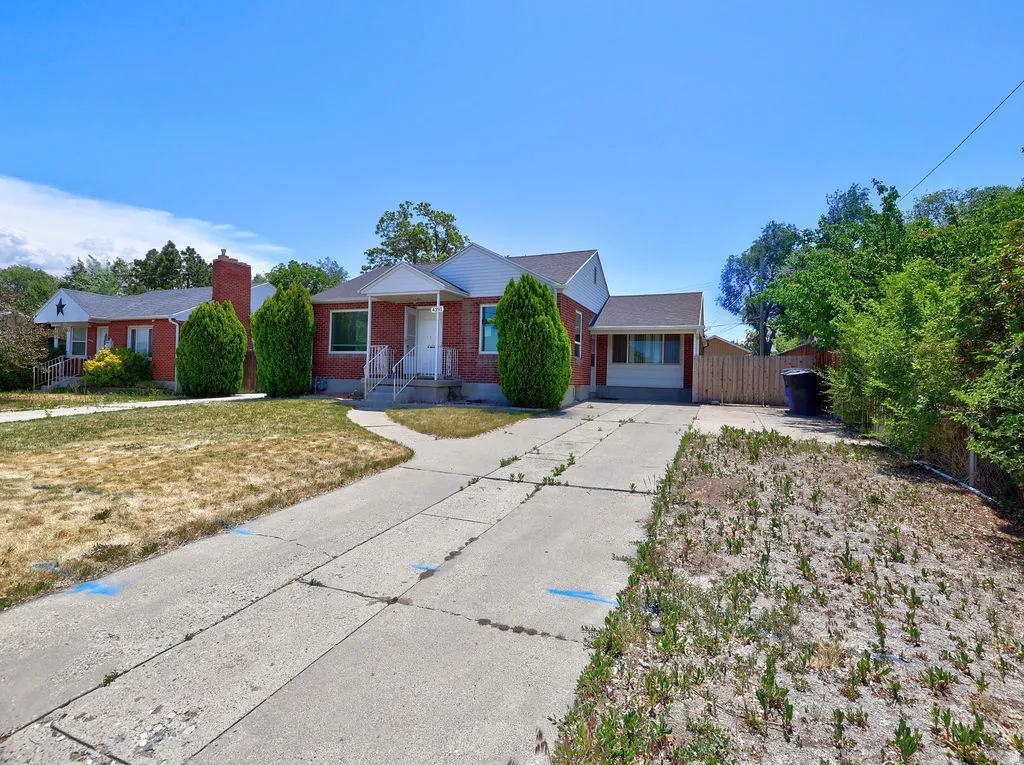 Brick exterior featuring a covered front porch and a paved driveway