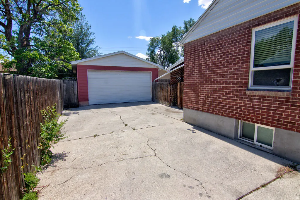 Detached two-car garage with a white overhead door and red siding