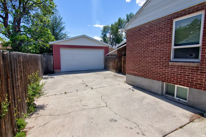 Detached two-car garage with a white overhead door and red siding