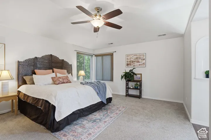 Spacious room featuring carpeting, light-toned walls, and a ceiling fan with integrated lighting