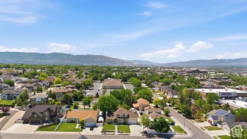 Residential community featuring a variety of architectural styles, mature trees, and mountainous terrain in the distance