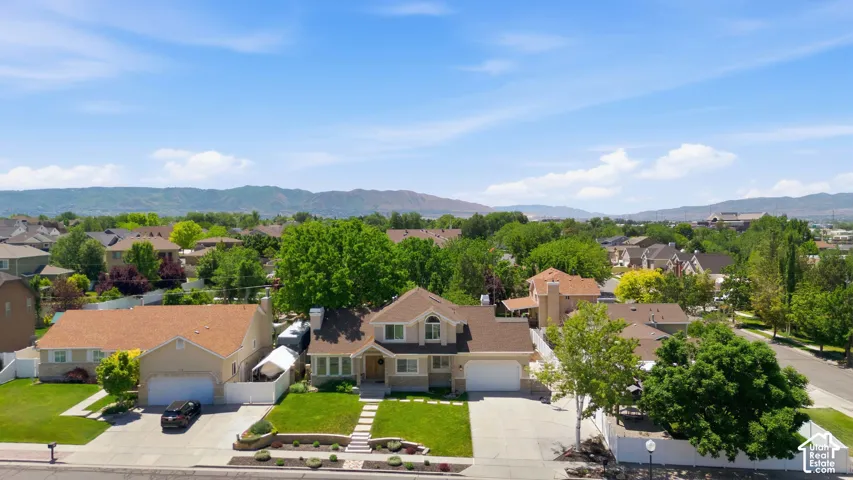 Aerial perspective showcasing a residential property with a multi-gabled roof and a light-toned exterior