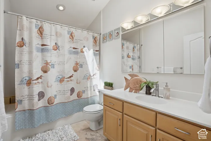Full bathroom with a tub/shower combination, recessed lighting, and a light wood-finish vanity with a white countertop and integrated sink