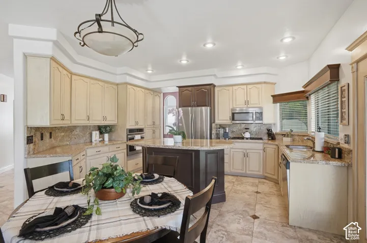 Kitchen featuring an expansive island with granite countertops, stainless steel appliances, recessed lighting, tile flooring, and custom cabinetry