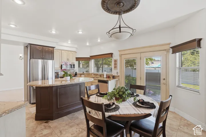 Kitchen featuring a central island with a light-toned countertop, recessed lighting, double French doors, and tile flooring