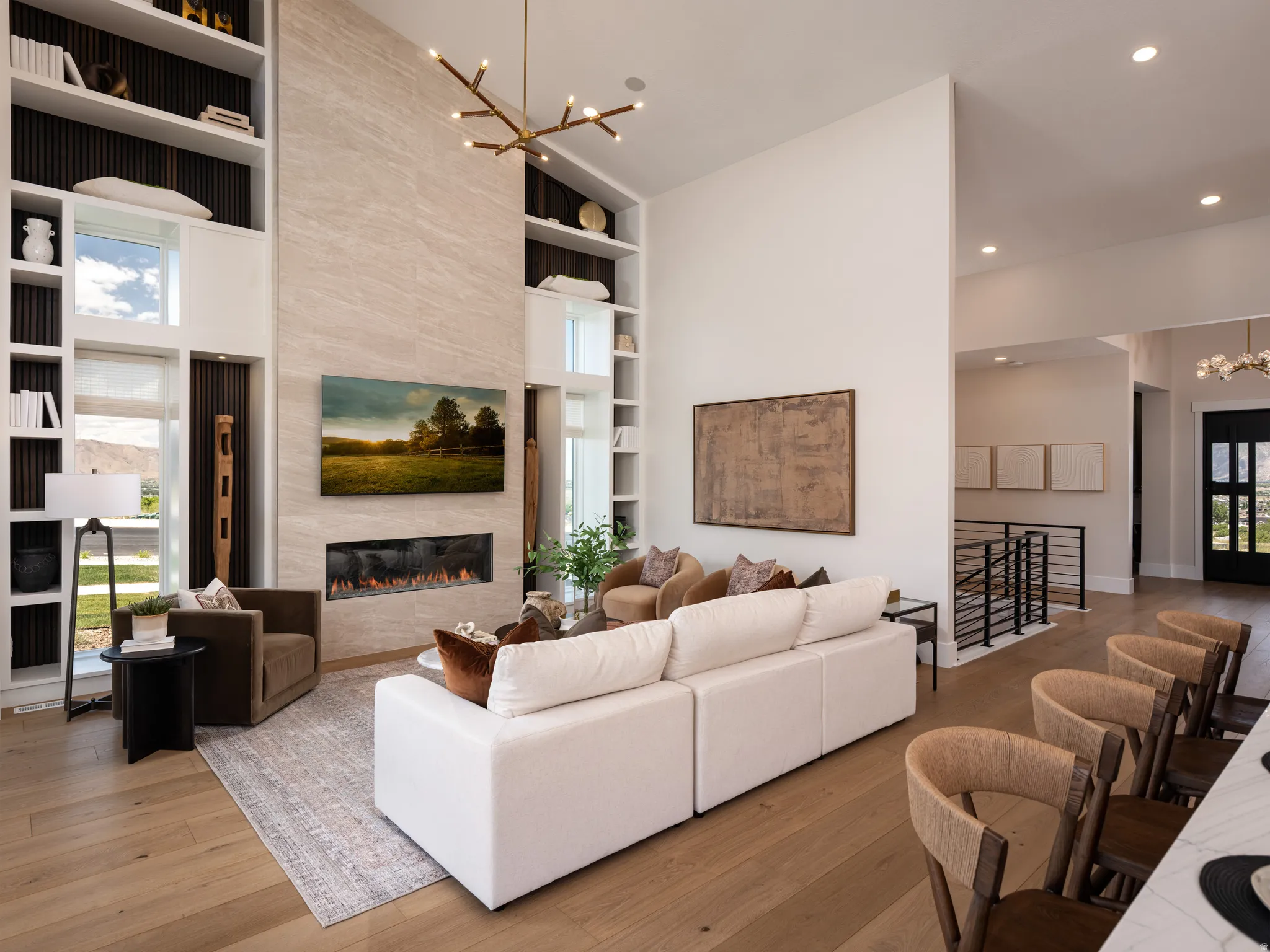 Vaulted living space featuring a floor-to-ceiling stone-clad fireplace and integrated media wall
