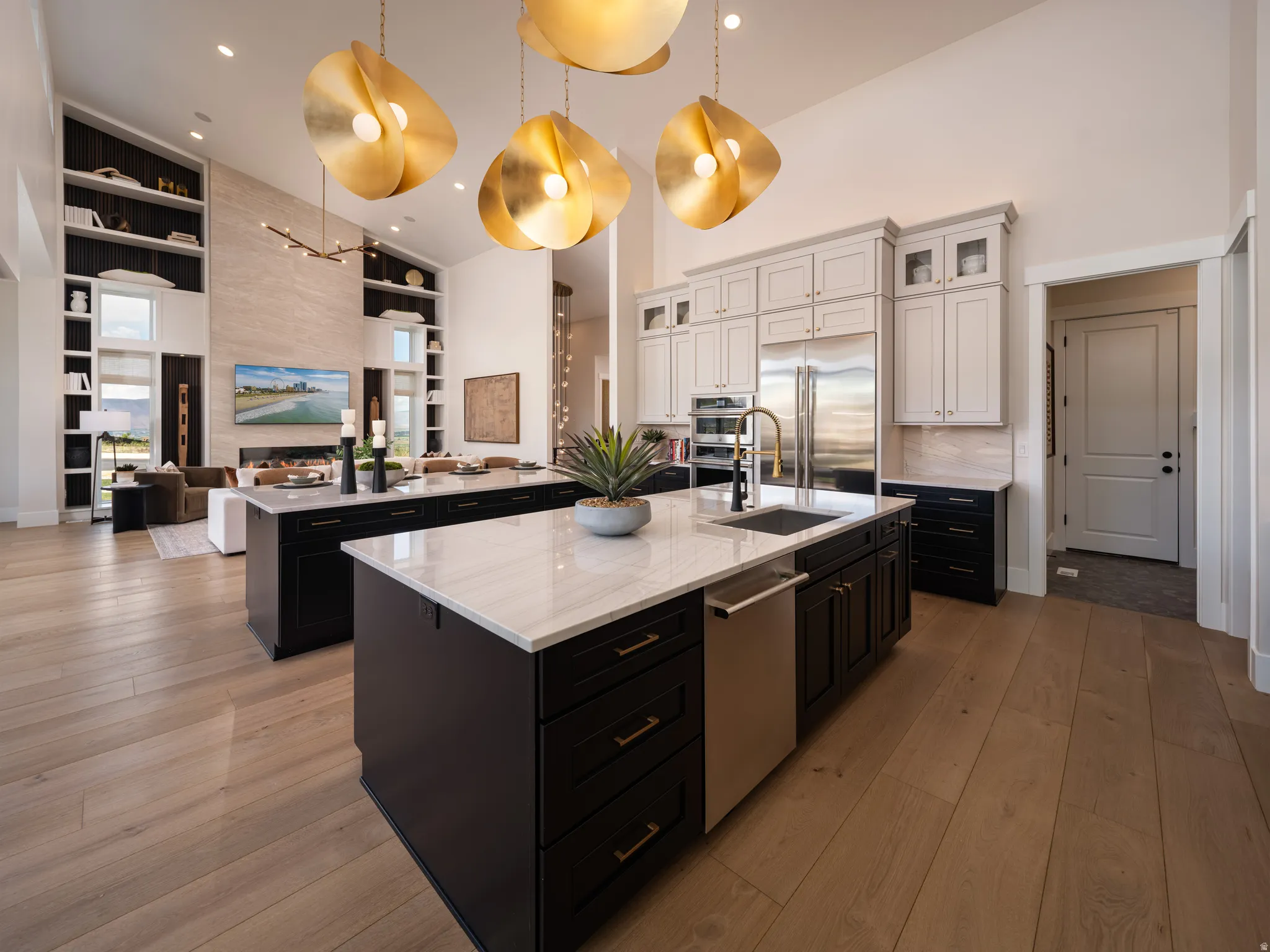 Gourmet kitchen with dual islands featuring quartz countertops, dark cabinetry, and integrated stainless steel appliances