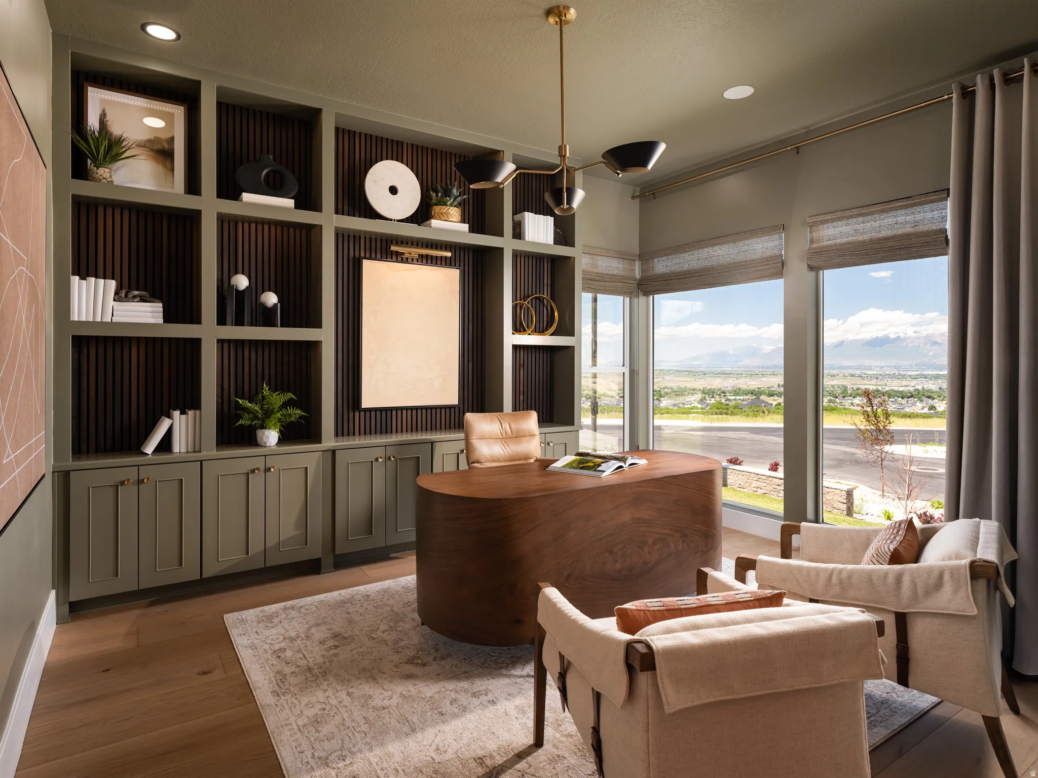 Dedicated office space featuring expansive windows, wood-finish flooring, and a built-in shelving unit with lower cabinetry
