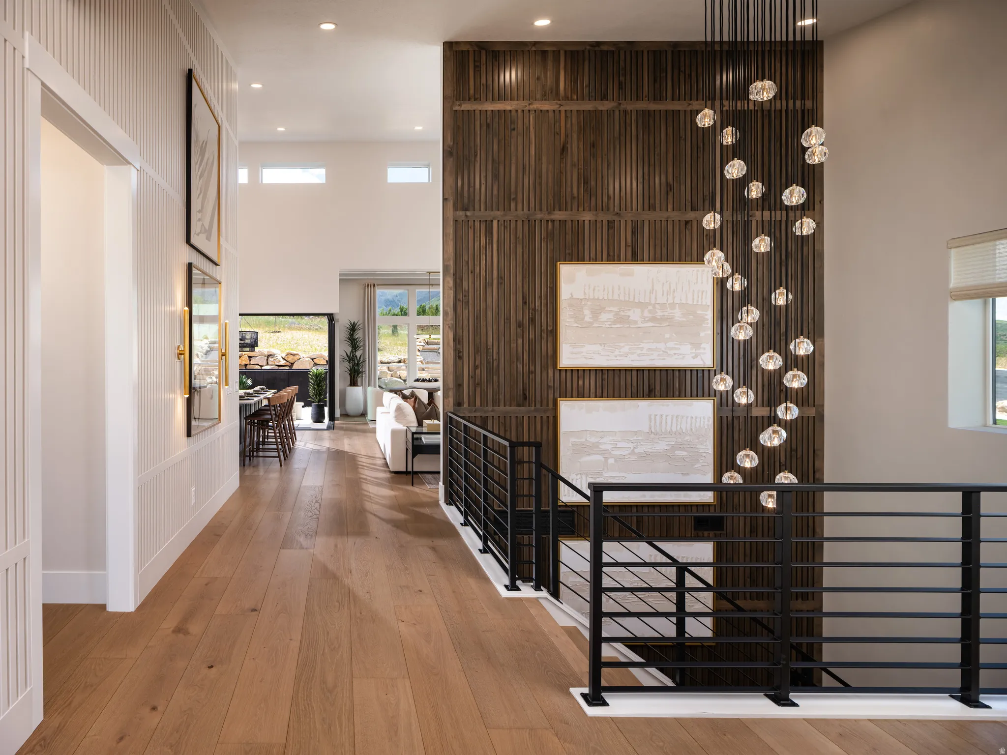 Wide plank wood-finish flooring throughout, complemented by a modern black metal railing system