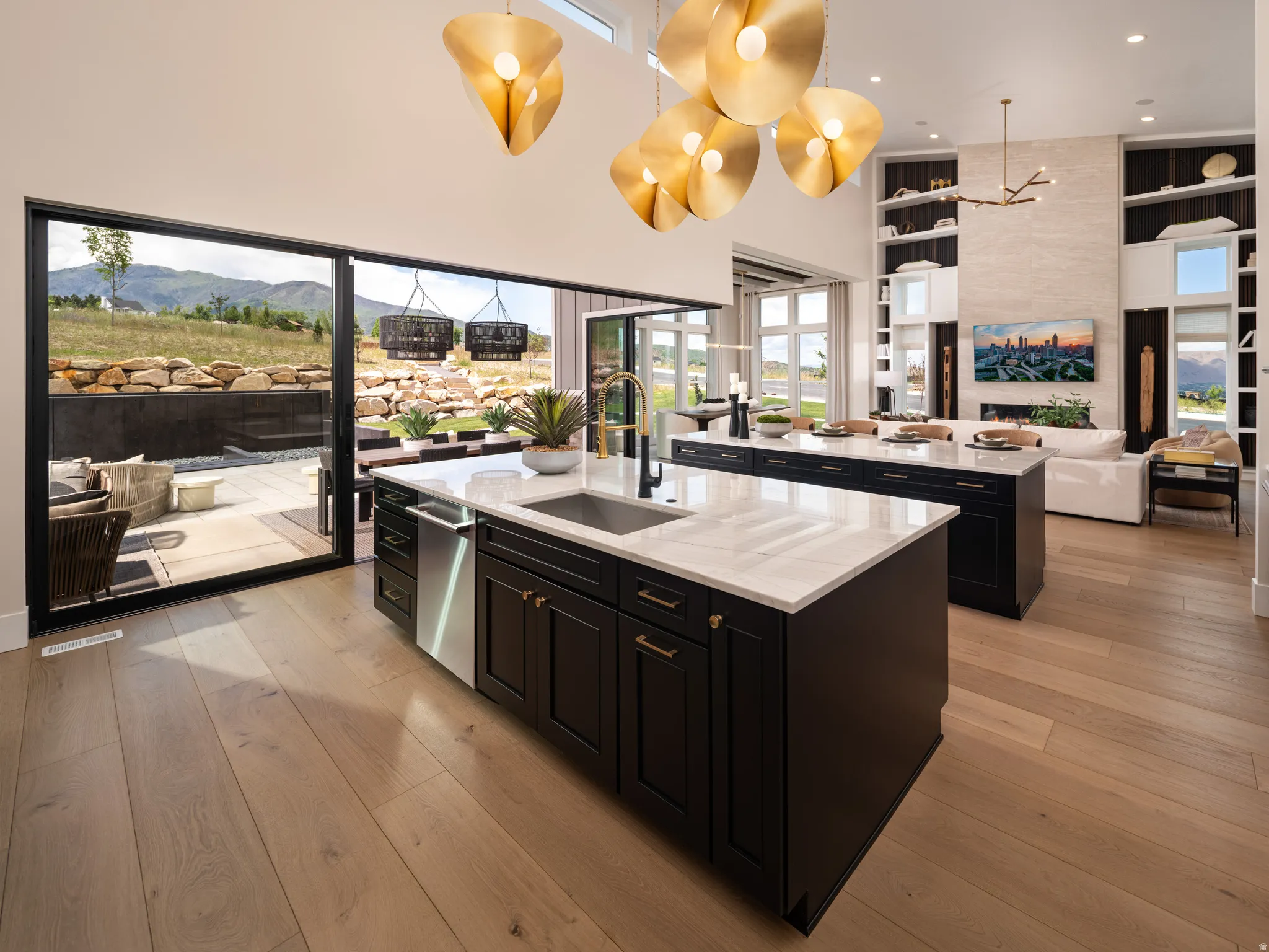 Gourmet kitchen featuring two dark-toned islands with white countertops, integrated sink, and stainless steel dishwasher