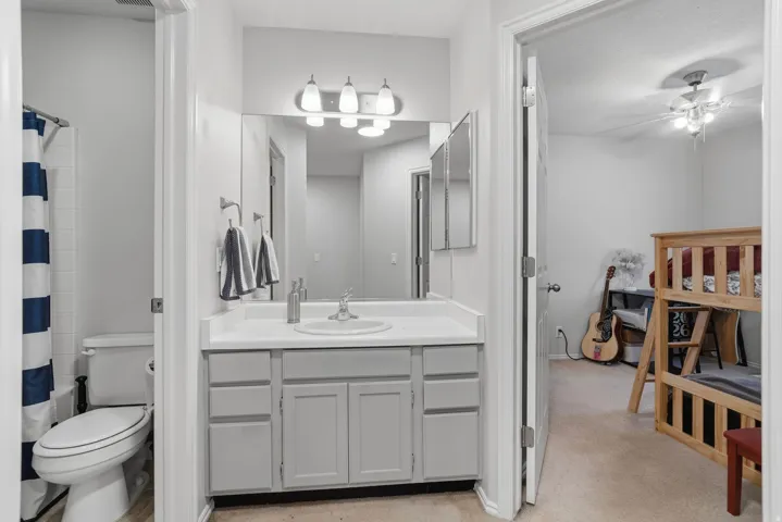 Bathroom featuring a single vanity with light grey cabinetry, a white countertop, and an integrated sink
