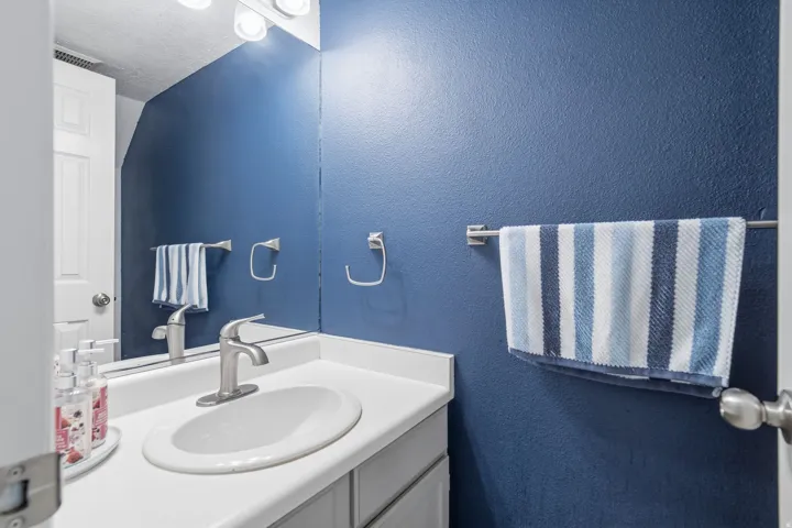 Bathroom vanity featuring a white countertop, oval sink, and brushed nickel faucet