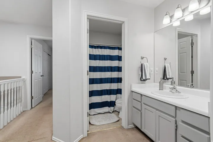 Bathroom vanity featuring a single basin sink, white countertop, and gray cabinetry