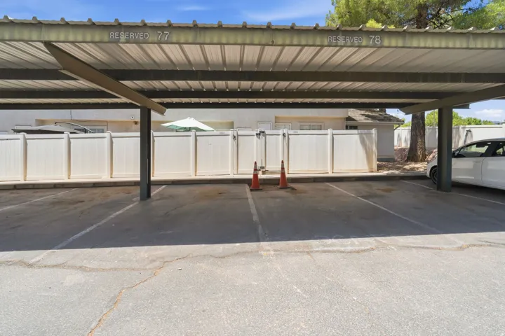 Reserved covered parking space with overhead metal roofing and designated parking lines