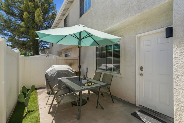 Private patio space featuring a concrete slab, white privacy fencing, and artificial turf accents