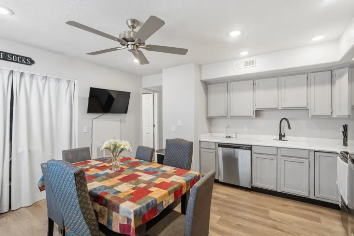 Kitchen and dining area featuring wood-finish flooring, recessed lighting, and a ceiling fan