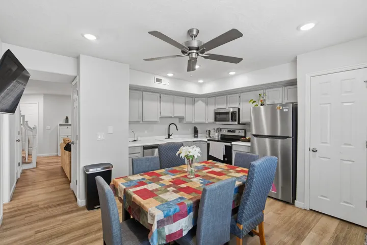 Kitchen featuring light gray cabinetry, stainless steel appliances, and wood-finish flooring