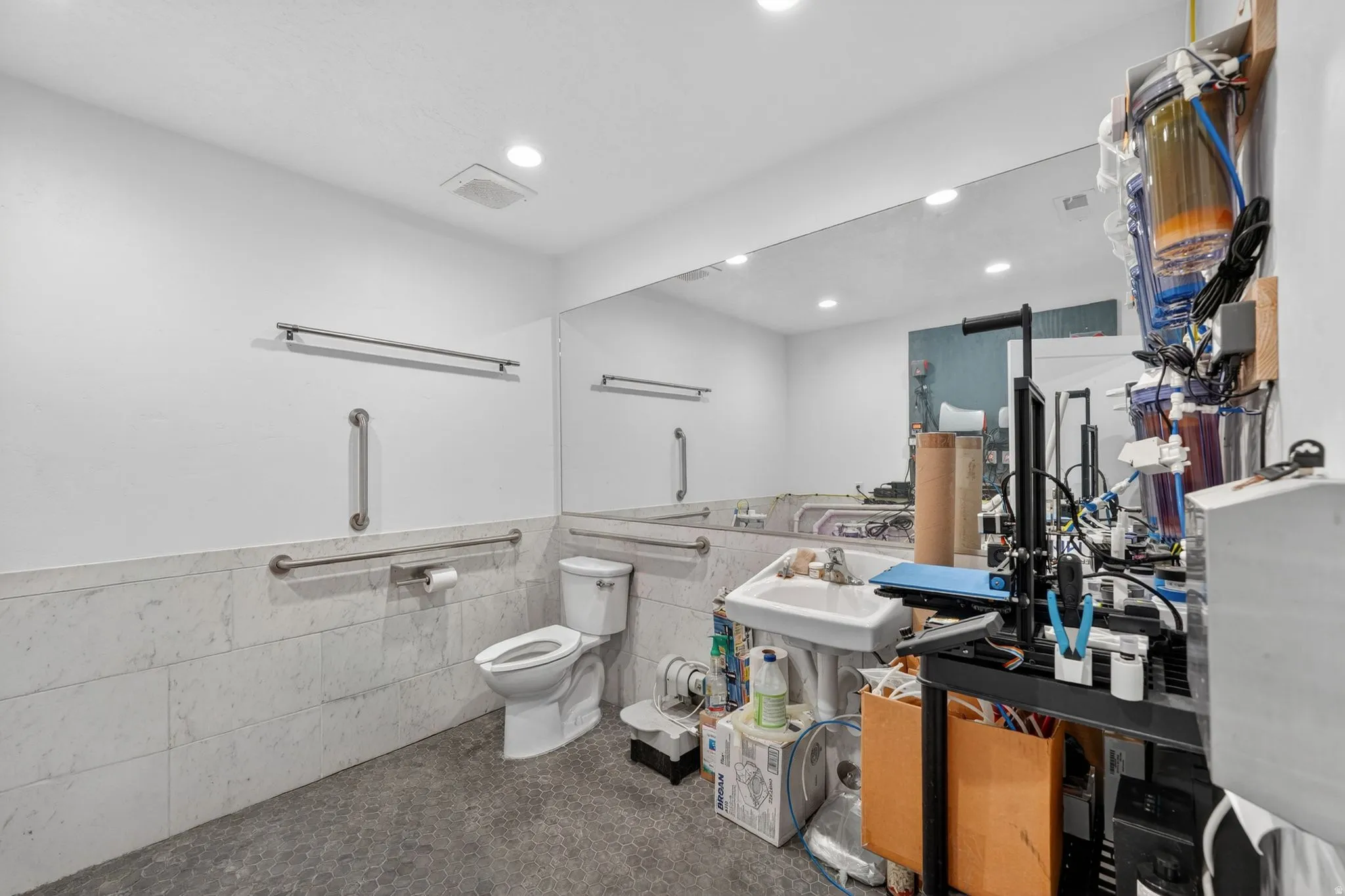 Floor-to-ceiling mirror with recessed lighting overhead
