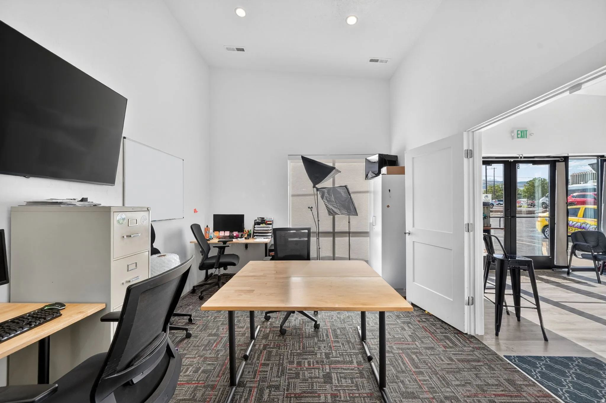 Spacious interior room featuring high ceilings, recessed lighting, and patterned carpet flooring