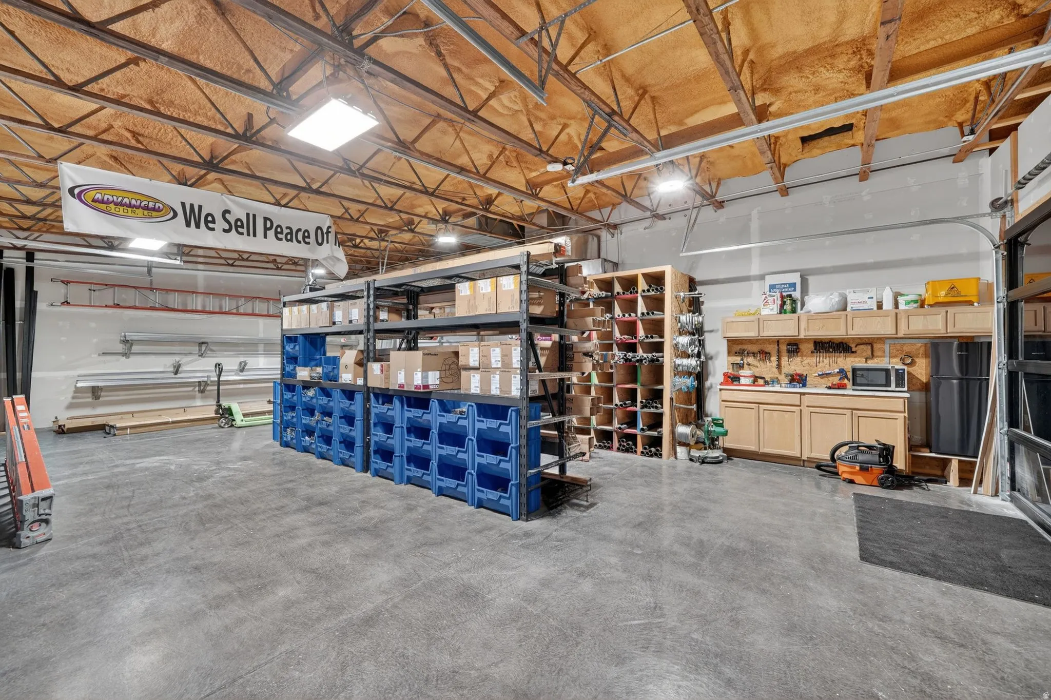 Spacious interior featuring a concrete floor, exposed structural beams, and insulated ceiling