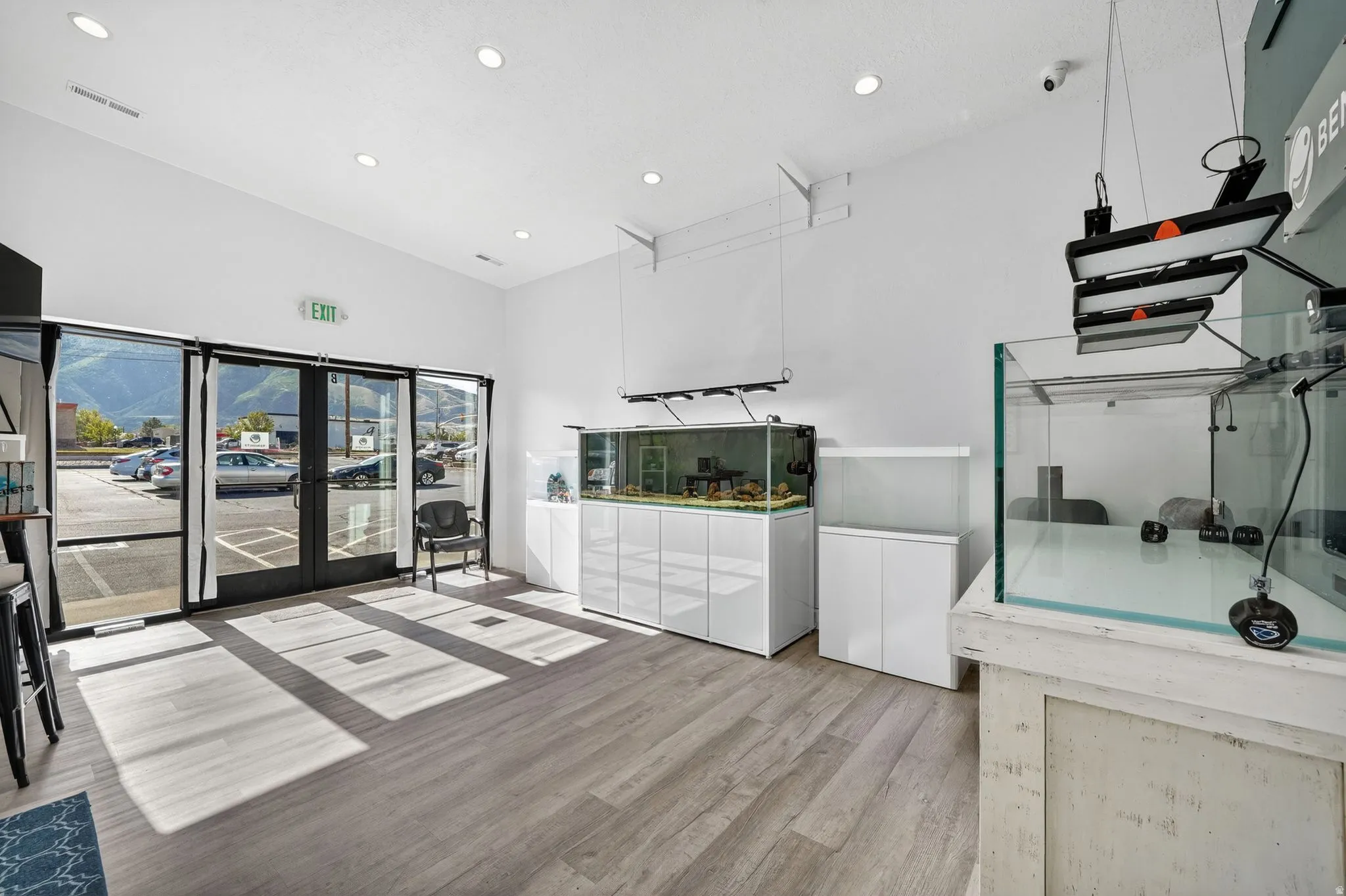 Commercial interior featuring wood-finish flooring, recessed lighting, and a glass storefront entrance