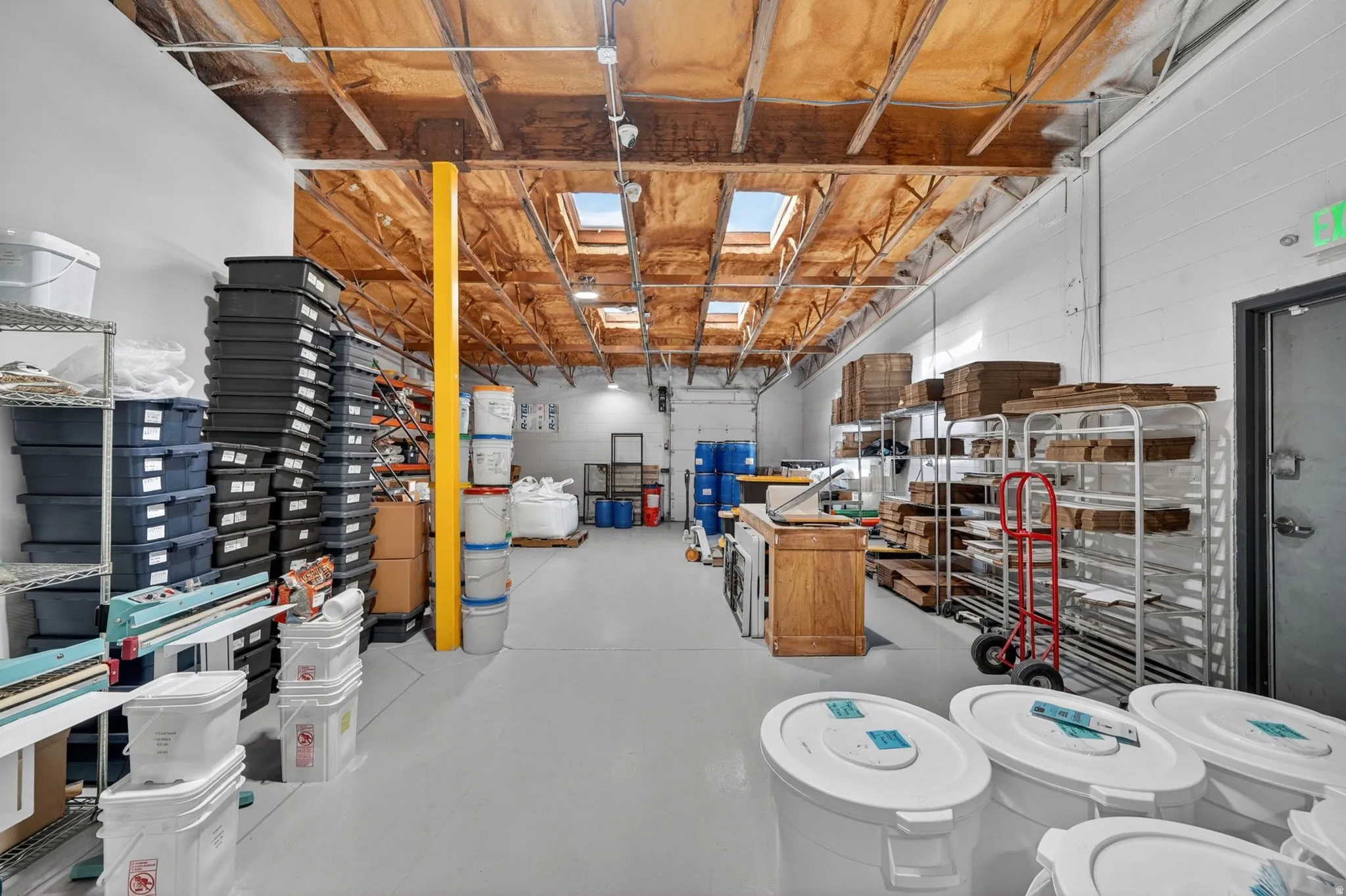High ceilings with exposed wood beams and multiple skylights