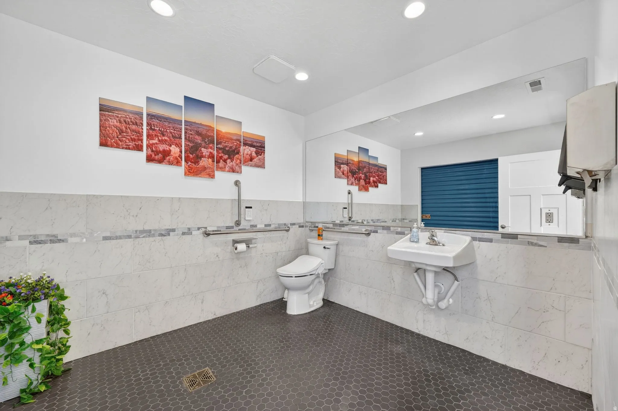 Spacious bathroom featuring hexagonal floor tiling and large format wall tiling