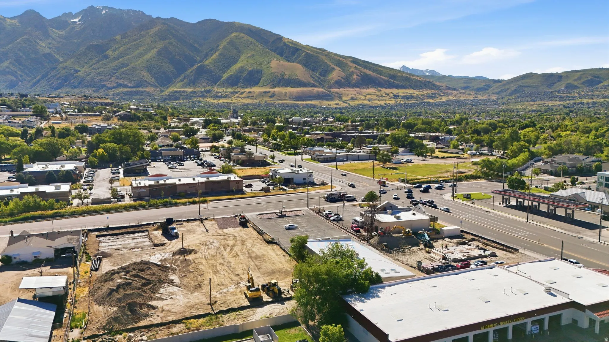 Expansive land parcel featuring cleared ground, mature trees, and mountainous terrain in the background