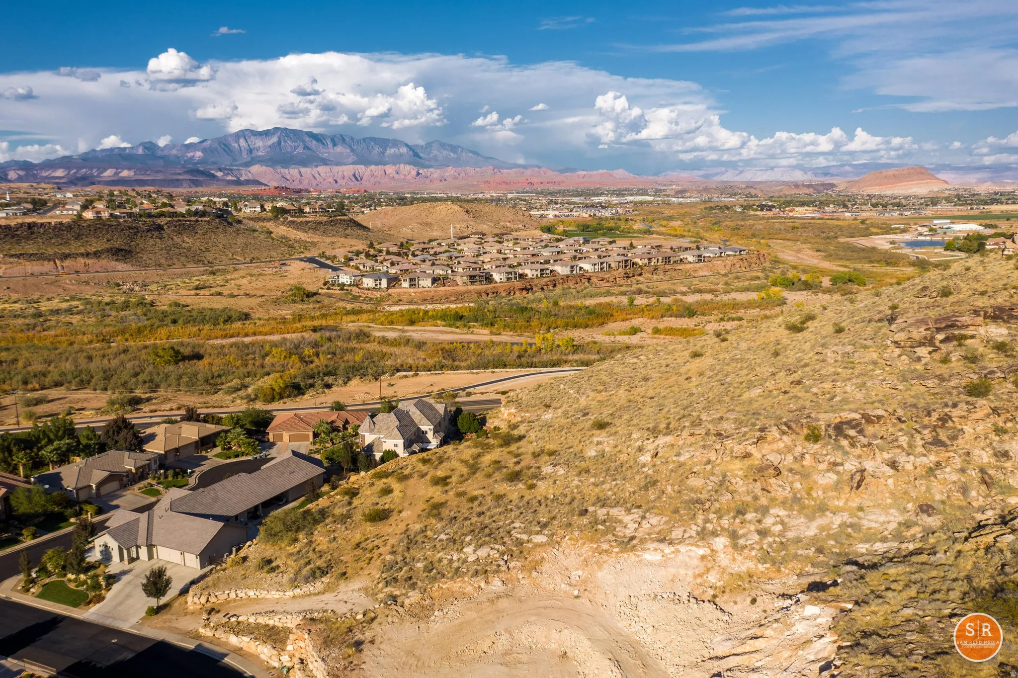 Expansive desert landscape featuring rugged terrain and distant red rock formations