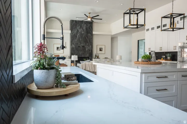 Modern kitchen featuring a large island with white cabinetry and light-toned countertops