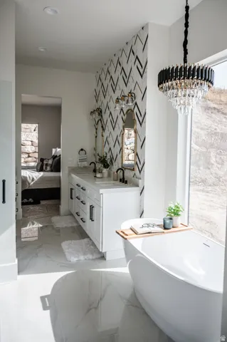Freestanding soaking tub with a modern chandelier overhead