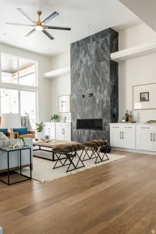 Floor-to-ceiling fireplace with dark stone surround and linear firebox, complemented by surrounding white cabinetry with dark hardware